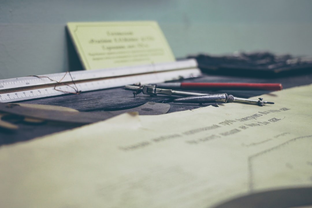 Graphic designer's drafting desk with vintage tools and paper layouts